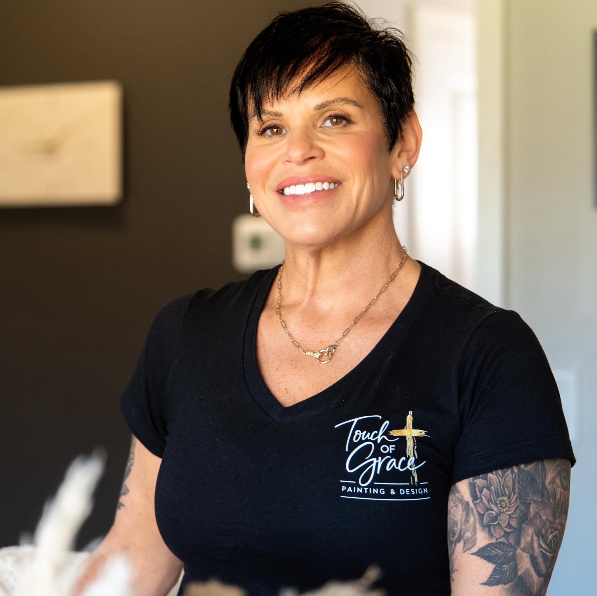 Tammy, owner of Touch of Grace, smiling in a Touch of Grace shirt